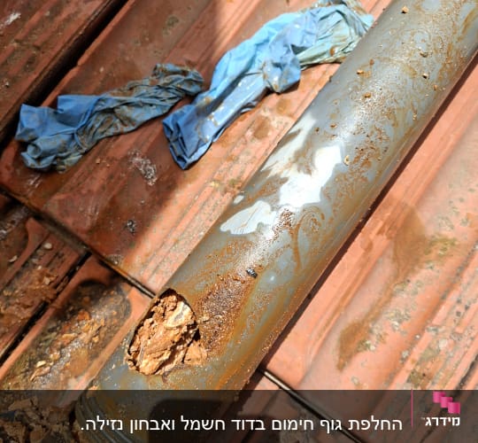 צינור פגום עם חלודה על גג רעפים